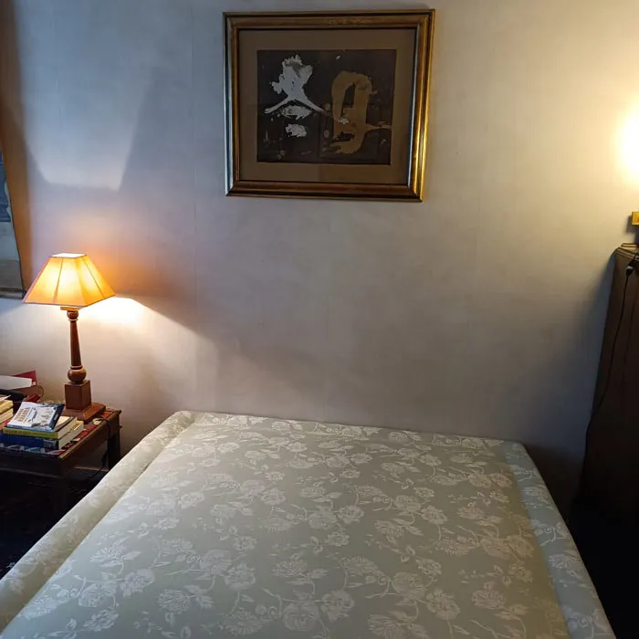 Sommier tapissier en damassé crème installé seul dans une chambre