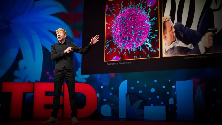 Matt Walker sur la scène TED, devant les lettres rouges du logo, commentant une image de cellule immunitaire projetée derrière lui.